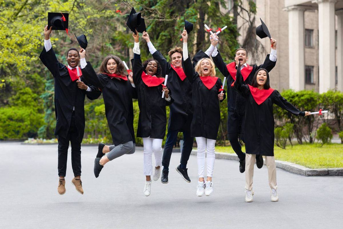 Graduates jumping and celebrating on campus
